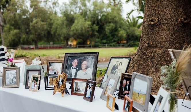 Personal photograph display arranged outdoors under a tree as part of a celebration of life
